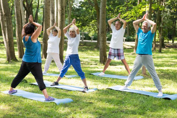 Yoga teacher and seniors in a park