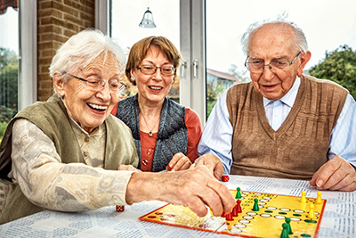 Elderly couple and daughter playing board game